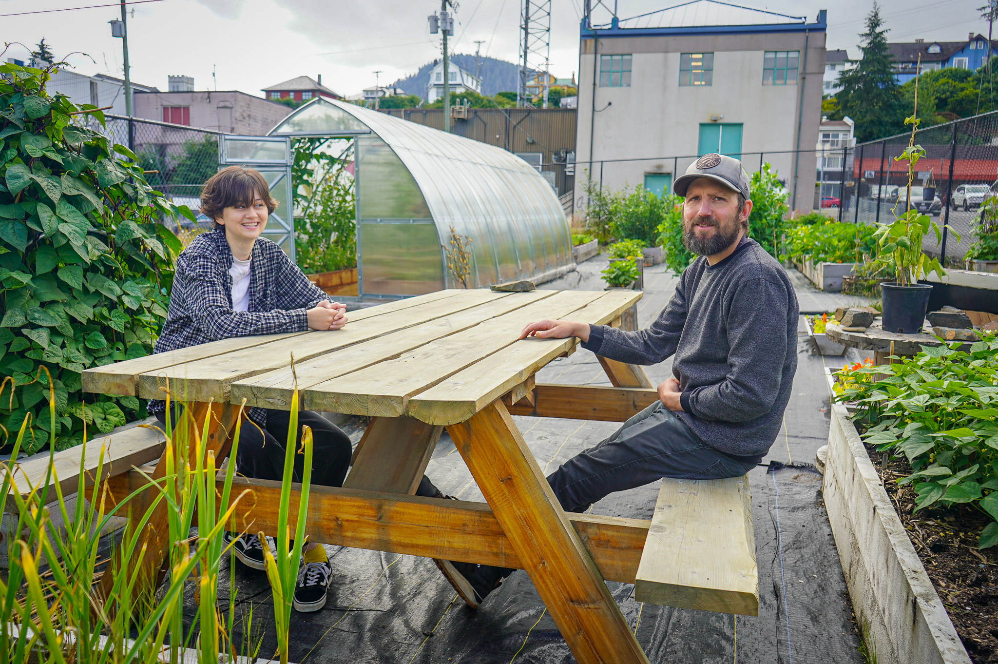 Summer Community Worker, Caterina Cociani, and Food Systems Coordinator, Charles Gerein (right), in Sndoyntga LaxKx’een ada Maxłaxaała urban farm in August, 2022. 