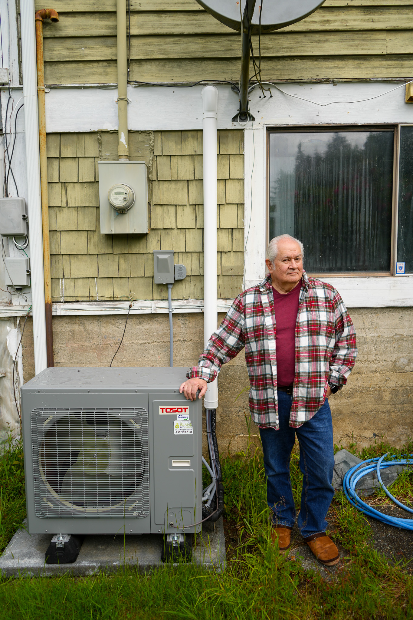 Jerry Olney, in Alert Bay, stands in front of his new heat pump.