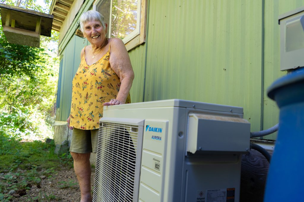 Carol Woolsey with her recently installed heat pump system in her home on Quadra Island, BC.